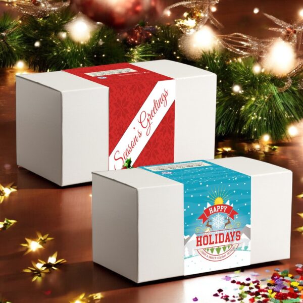 Holiday cookie gift boxes with festive greetings on wooden table